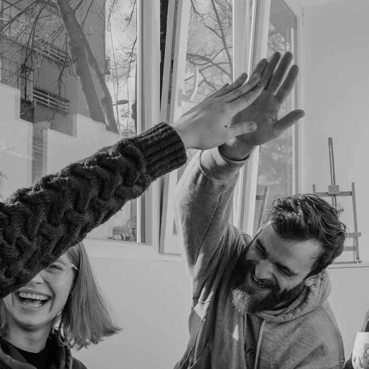Un groupe de personnes dans une salle, levant les mains en signe d'approbation ou d'enthousiasme.